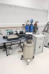 Zbiór różnych przyrządów składających się na stanowisko pomiarowe w laboratorium.