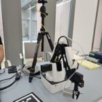 Na blacie stołu stoi kilkuelementowy przyrząd.