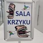 Na niedużym plakacie napis "Sala krzyku". Obok napisu namalowane dwie śmieszne rozciągnięte twarze.