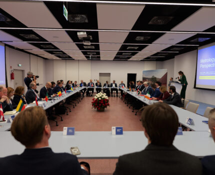 Uczestnicy spotkania siedzą przy stołach w sali konferencyjnej.